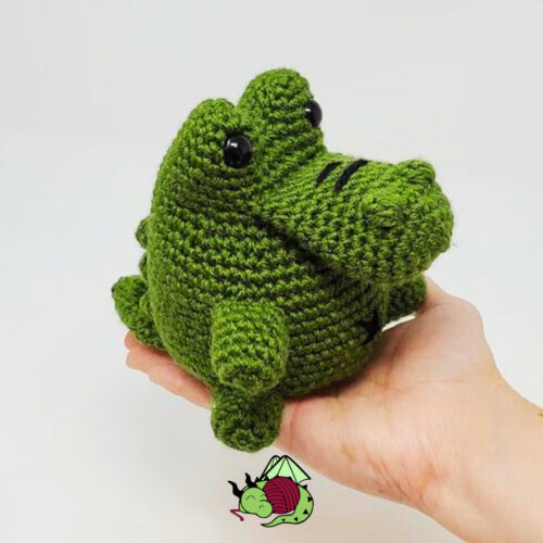 small crochet no-sew alligator amigurumi held in hand, pattern