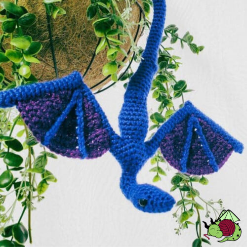 crochet blue little dragon amphithere, hanging upside down from a plant
